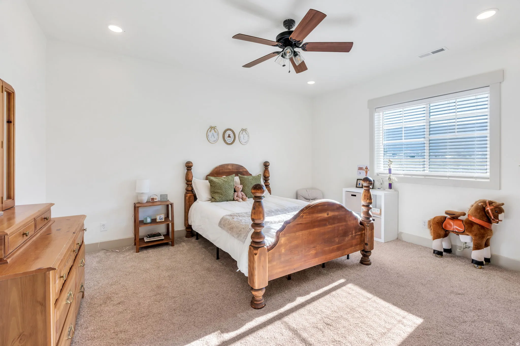 Carpeted room featuring a ceiling fan with integrated lighting, recessed overhead lighting, and a large window with horizontal blinds