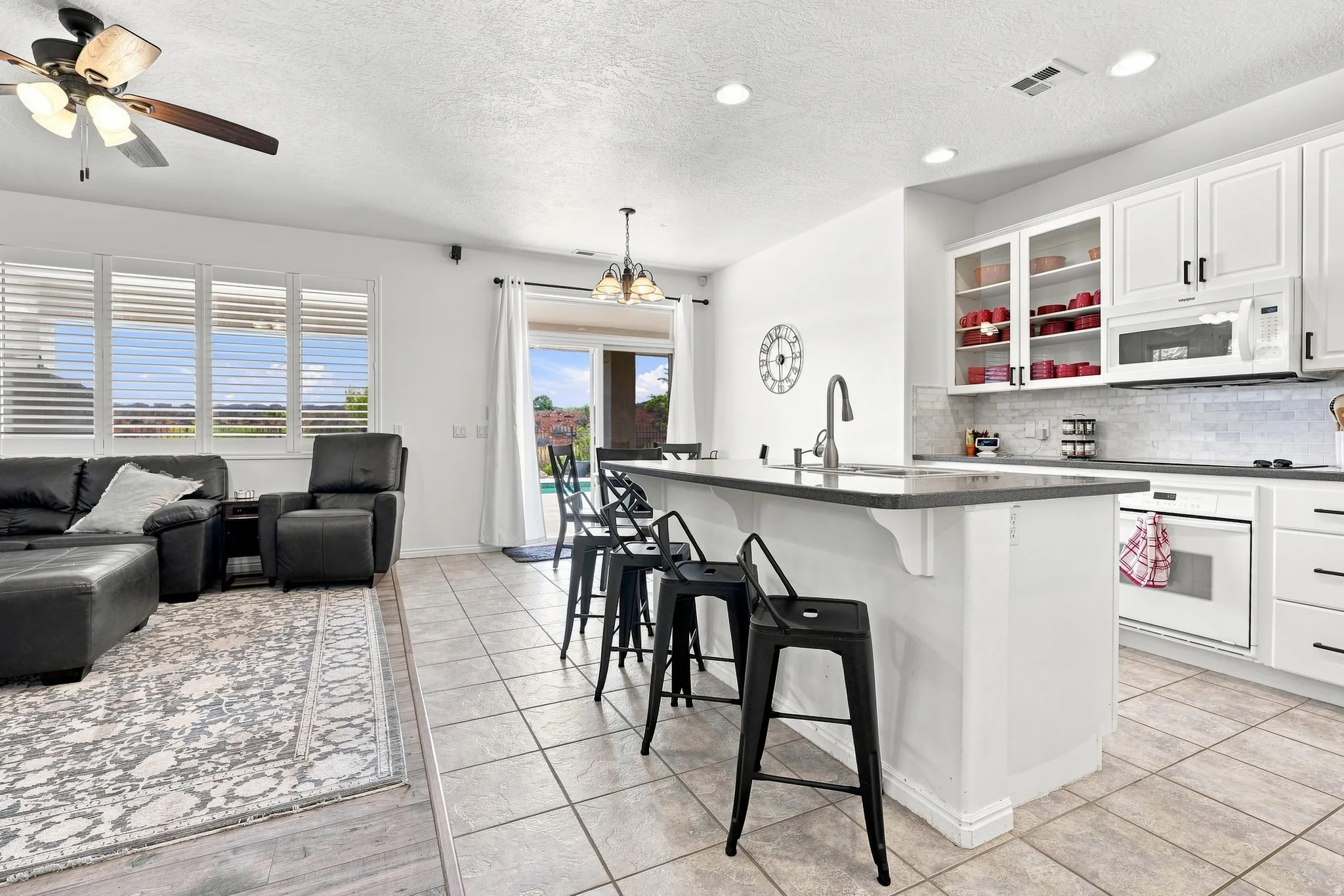 Kitchen featuring white cabinetry, dark countertops, a tiled backsplash, and recessed lighting