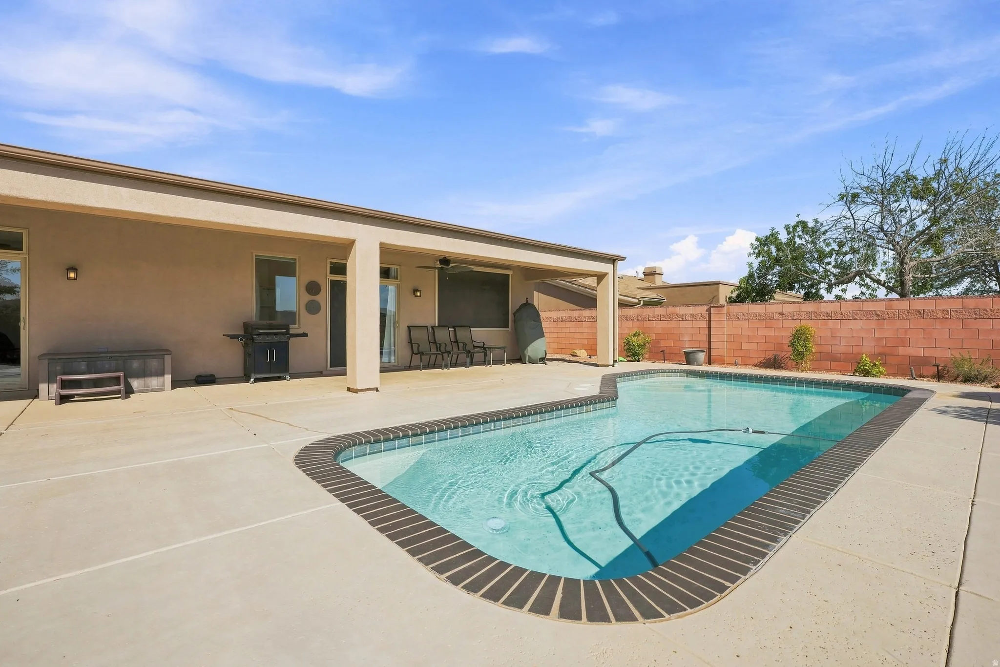 Backyard swimming pool with a curved edge and brick coping