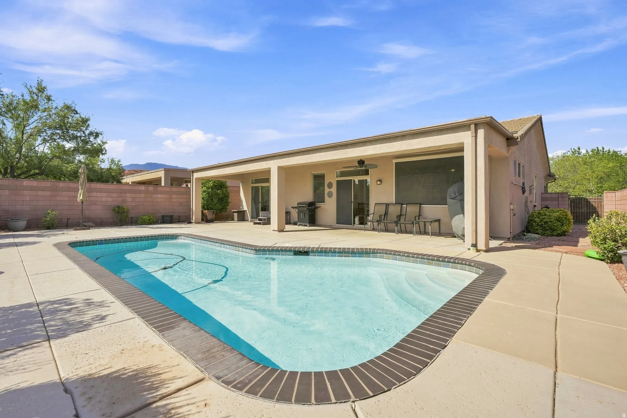 Backyard featuring a freeform swimming pool with brick coping