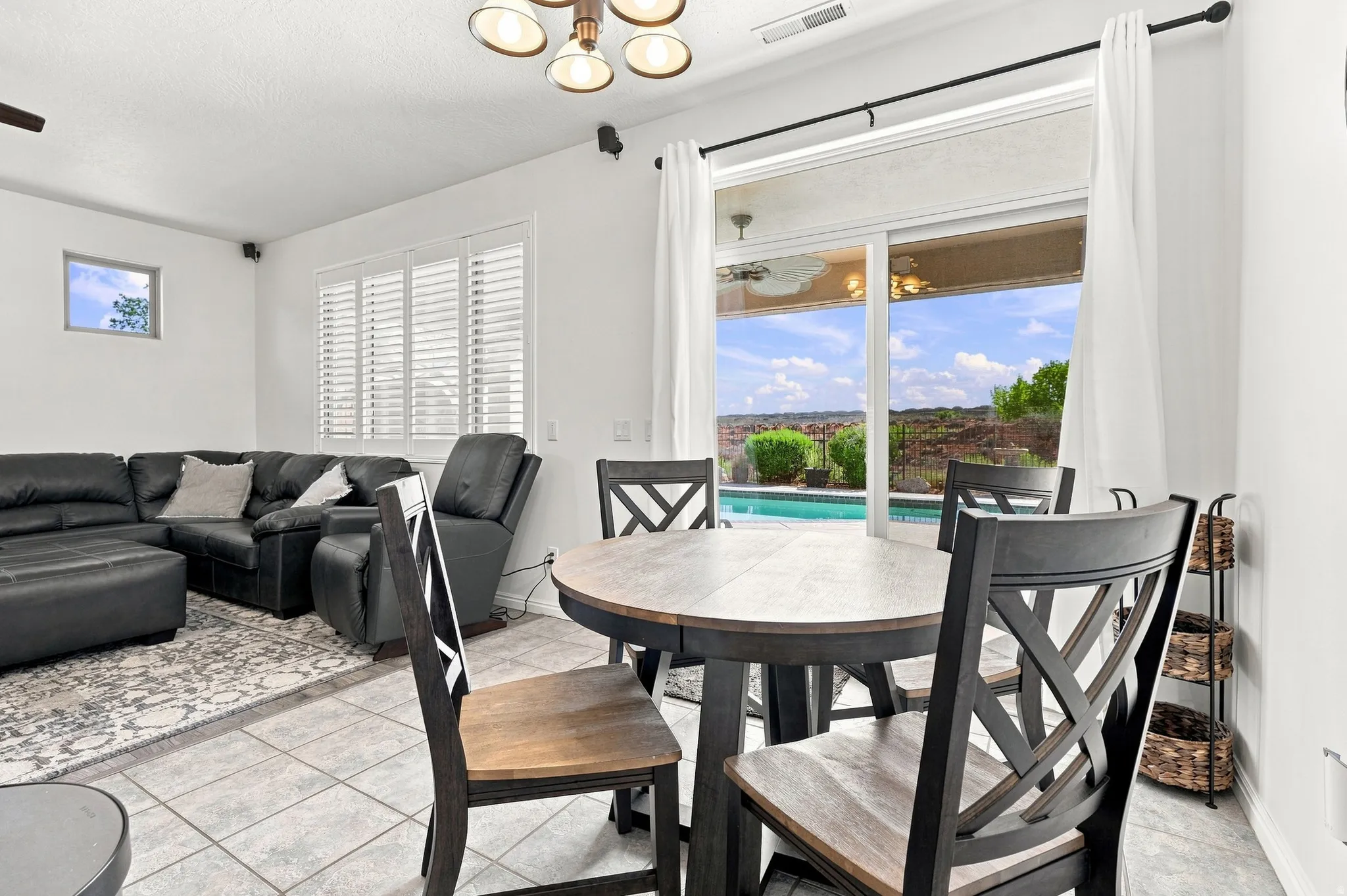 Sliding glass doors opening to an outdoor pool and distant landscape, complemented by tiled flooring