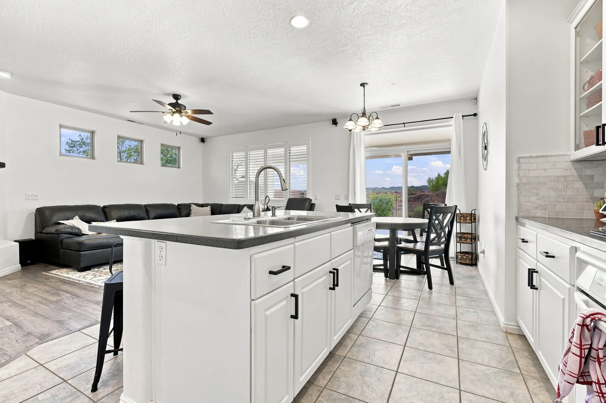Kitchen island featuring a double-basin sink and dark countertop