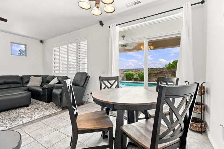 Sliding glass doors opening to an outdoor pool and distant landscape, complemented by tiled flooring