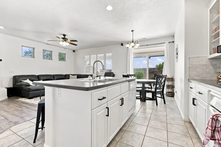 Kitchen island featuring a double-basin sink and dark countertop
