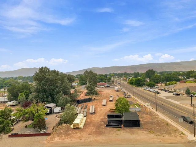 Expansive lot with direct road frontage, substantial open space, and a mountainous backdrop