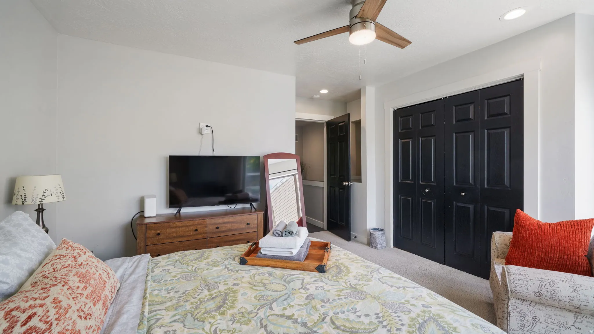 Bedroom featuring light gray walls, plush carpeting, a ceiling fan with light, recessed lighting, and dark paneled bifold closet doors