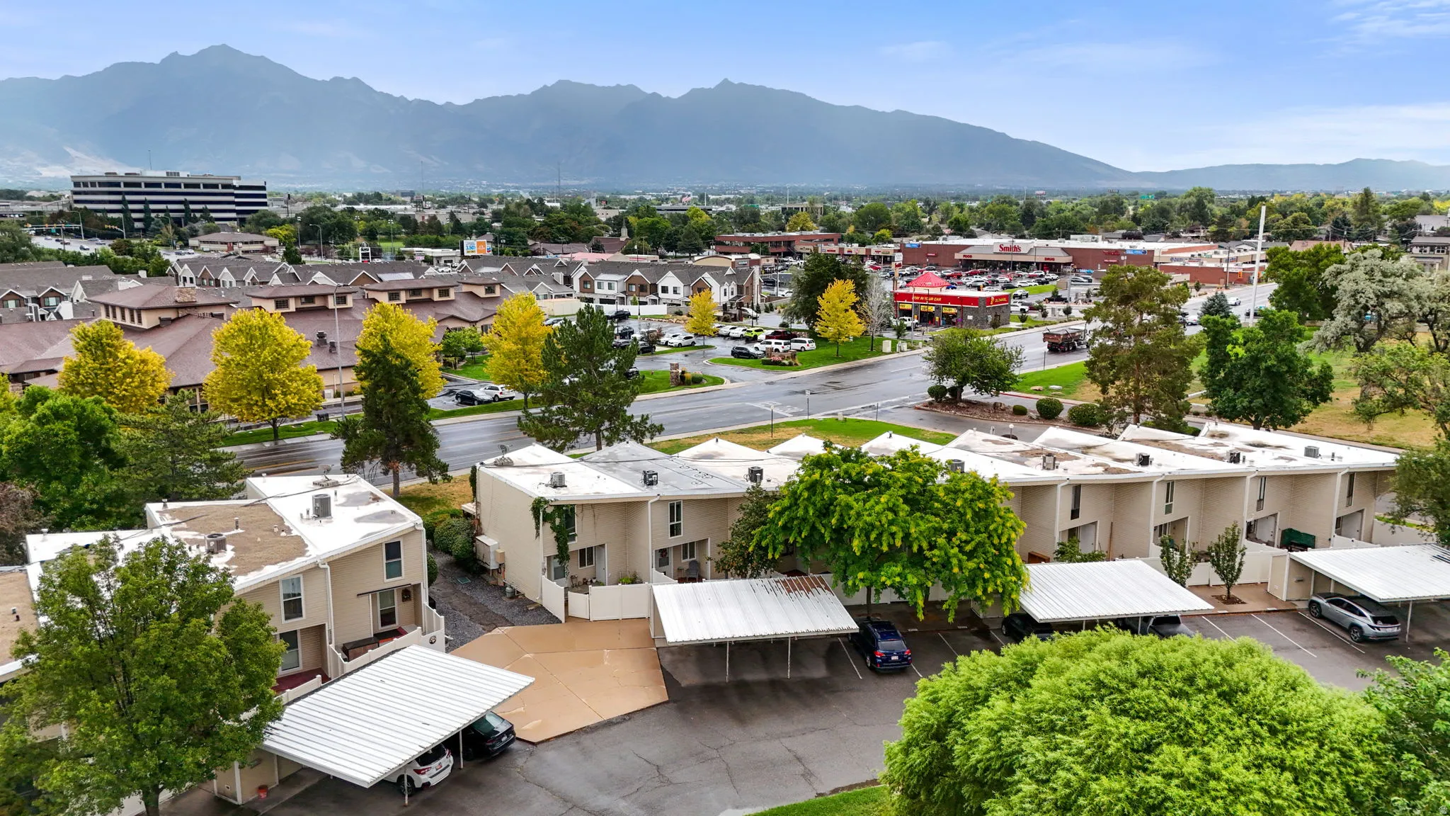Multi-unit property featuring covered parking structures and mature landscaping