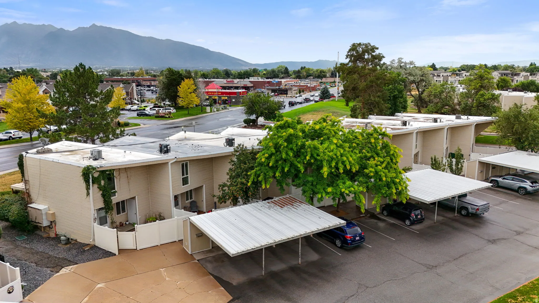 Multi-unit property featuring tan siding and multiple covered parking structures