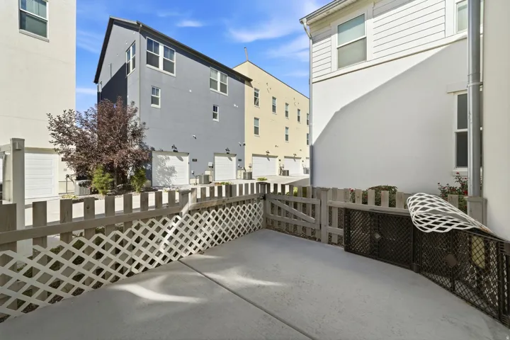 Paved patio area with a lattice fence and gated entry