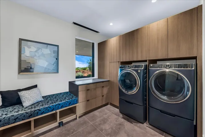 Laundry room featuring a built-in bench and custom wood  cabinetry