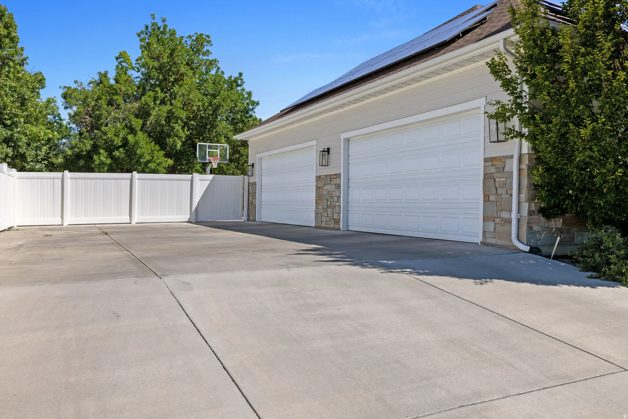 Spacious concrete driveway offering ample parking with four car garage