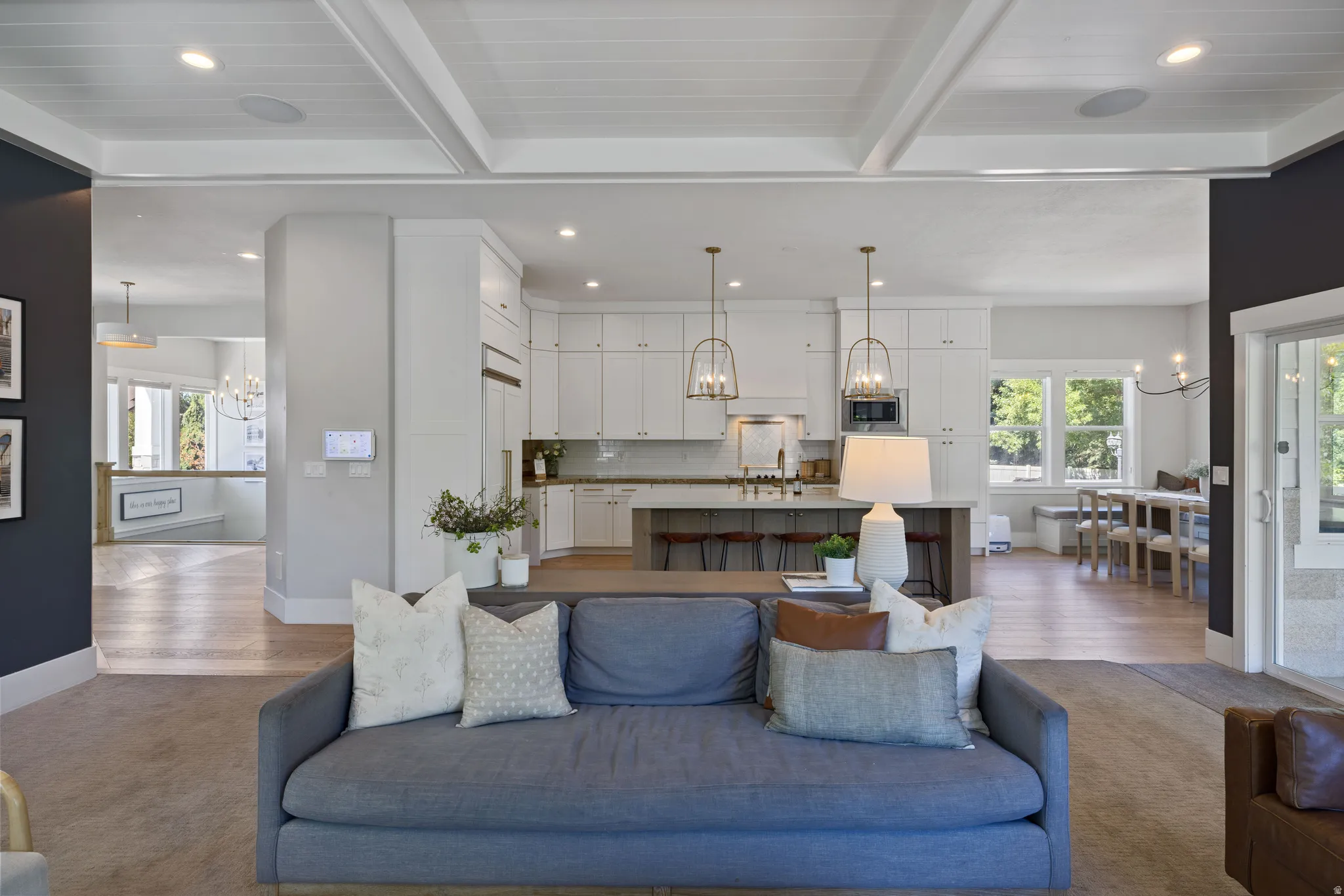 Open-concept living space with coffered ceilings and recessed lighting