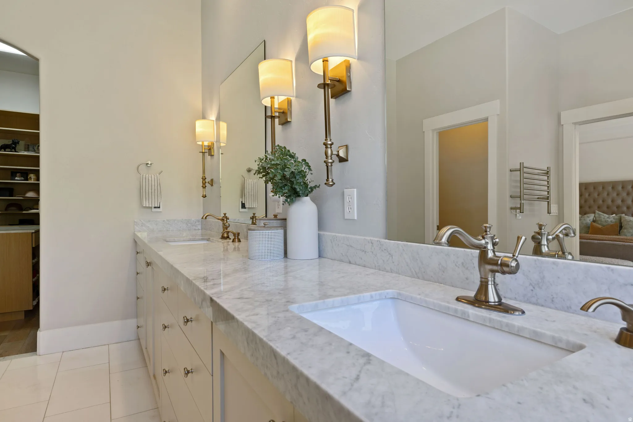 Primary bathroom dual vanity with integrated sinks, light-toned countertops, and brushed nickel faucets