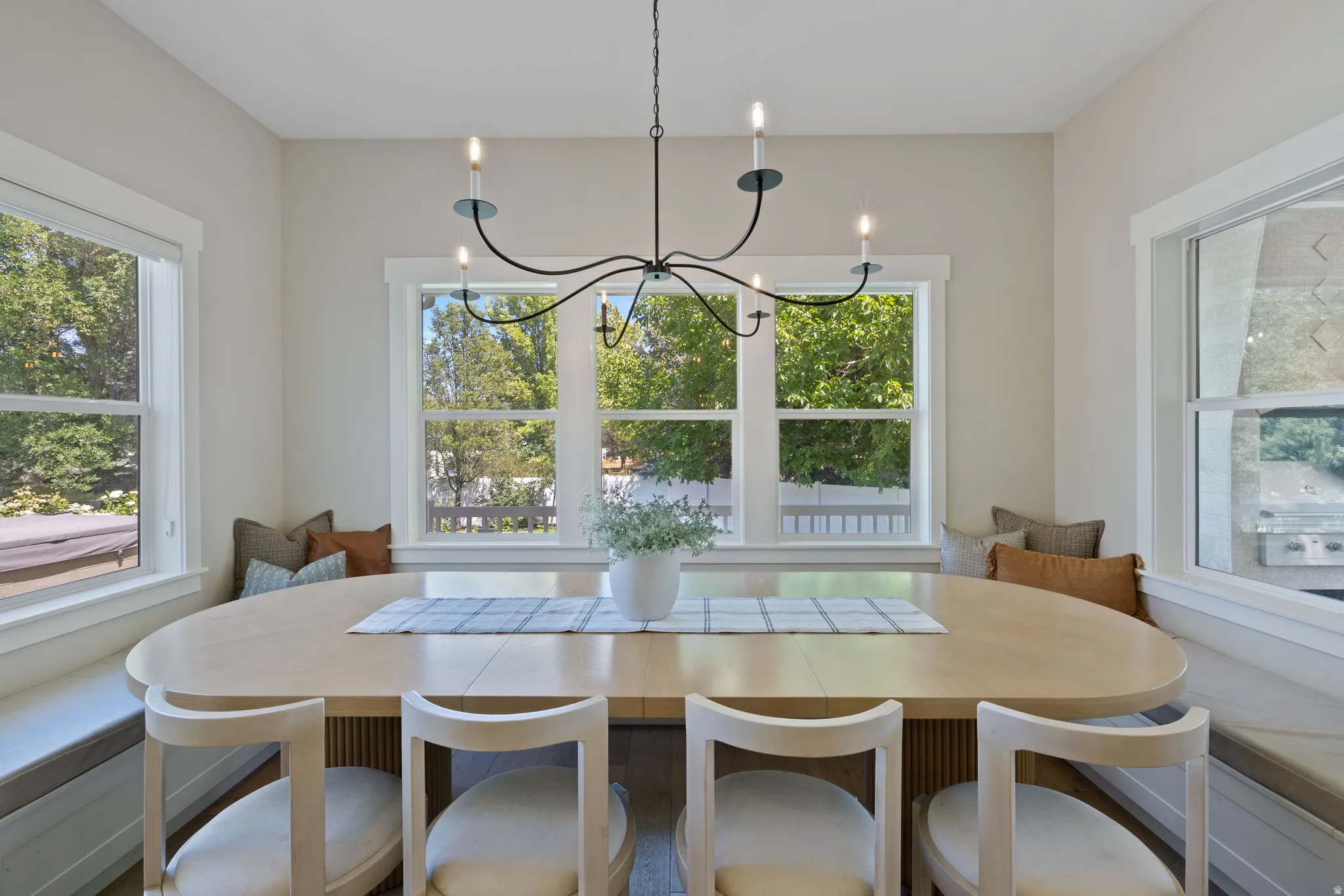 Built-in dining nook with integrated bench seating and multiple large windows to overlook the backyard.