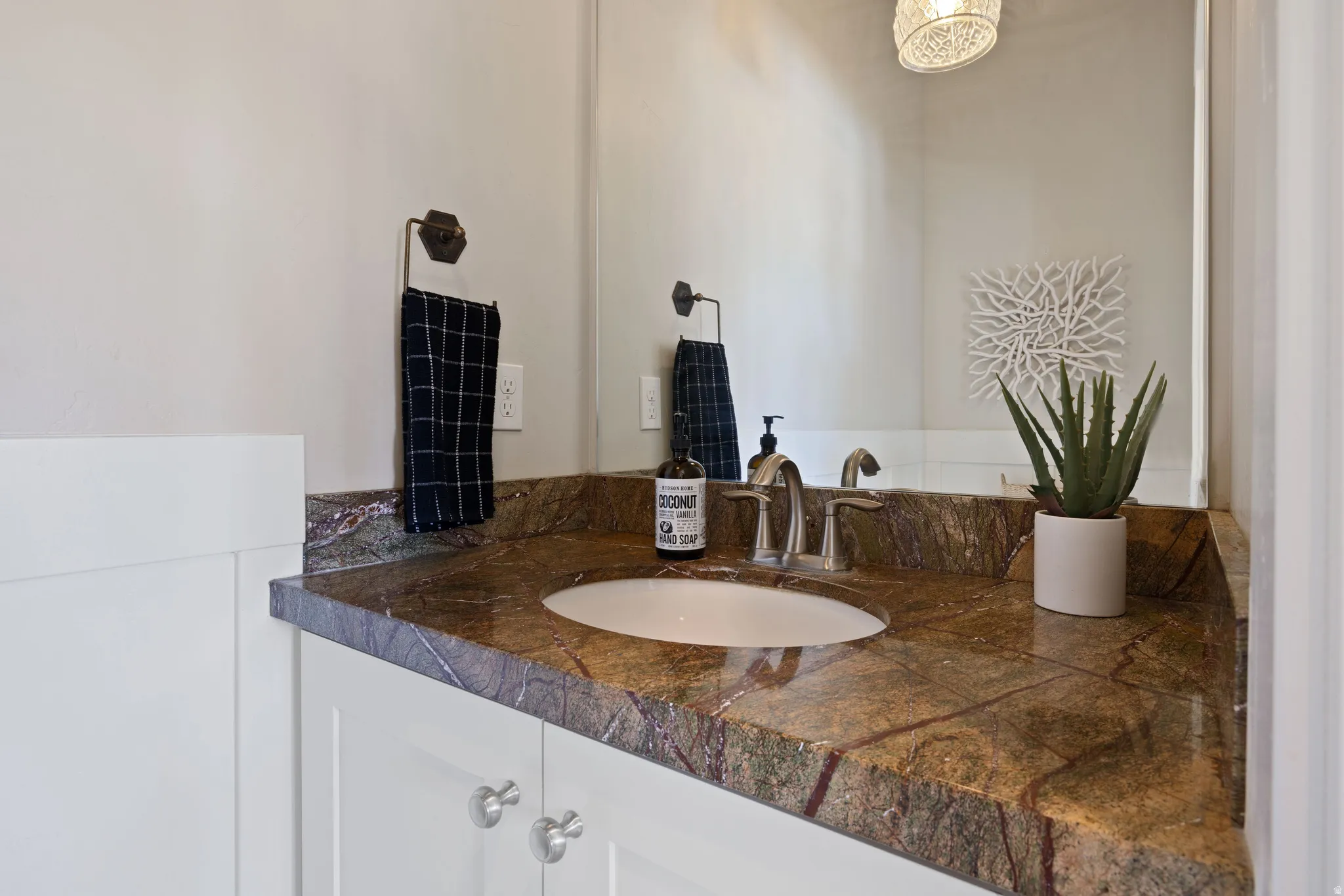 Main floor powder bathroom with a polished stone countertop and an under mount sink.