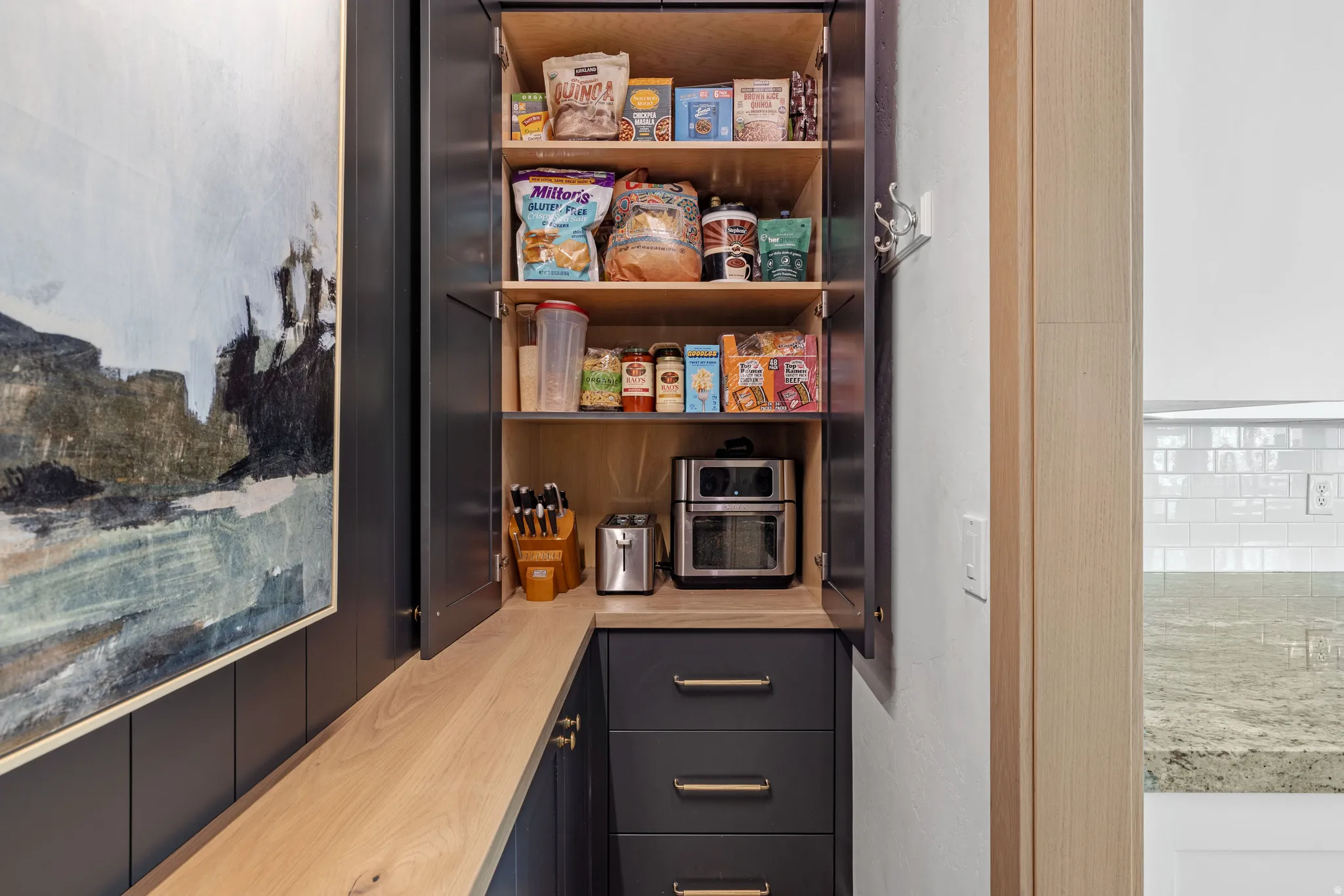 Custom built-in pantry cabinetry with wood-finish shelving and dark blue matte soft close doors and drawers