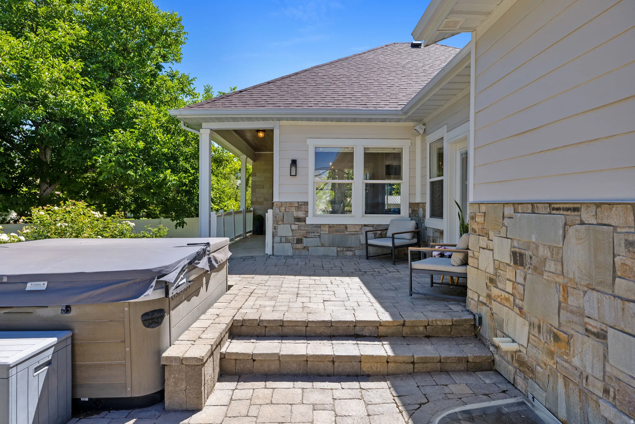 Patio featuring stone paver flooring and hot tub just off the primary bedroom entrance