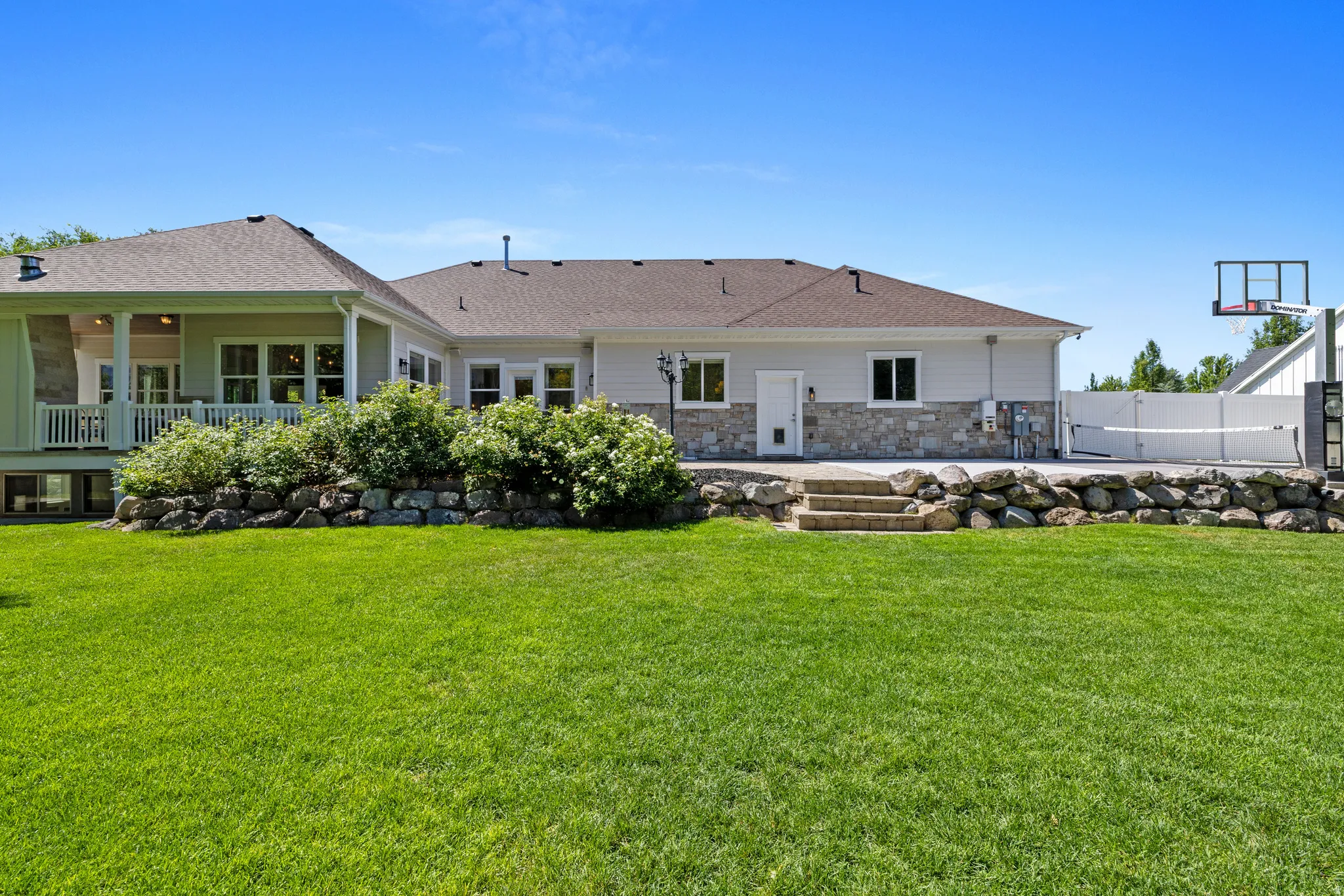 Expansive green lawn with a retaining wall featuring integrated landscaping