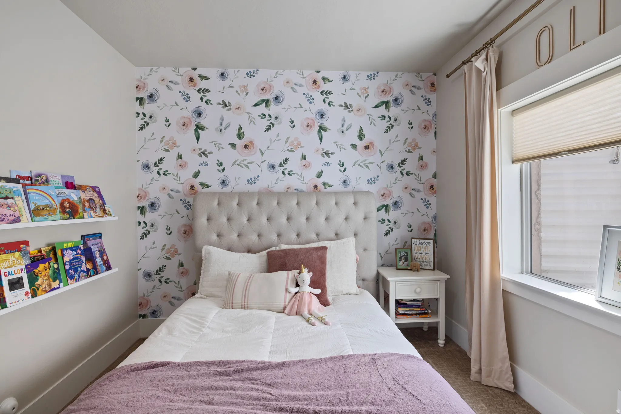 Bedroom with Accent wall featuring floral wallpaper and a tufted headboard