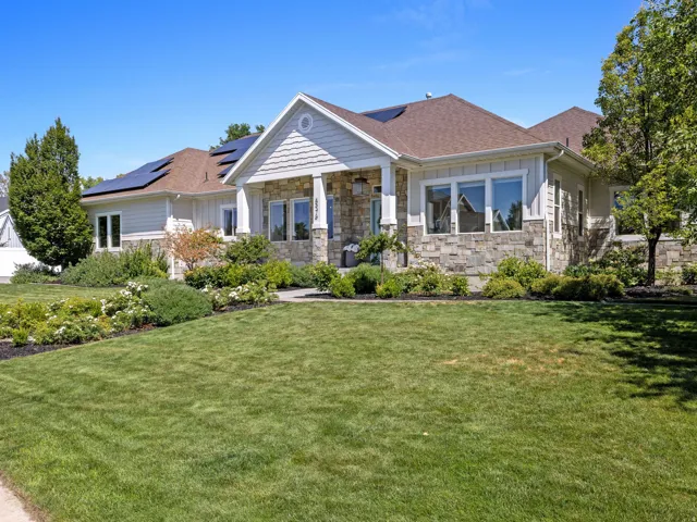 Stone and siding exterior with a covered entry and multiple solar panels