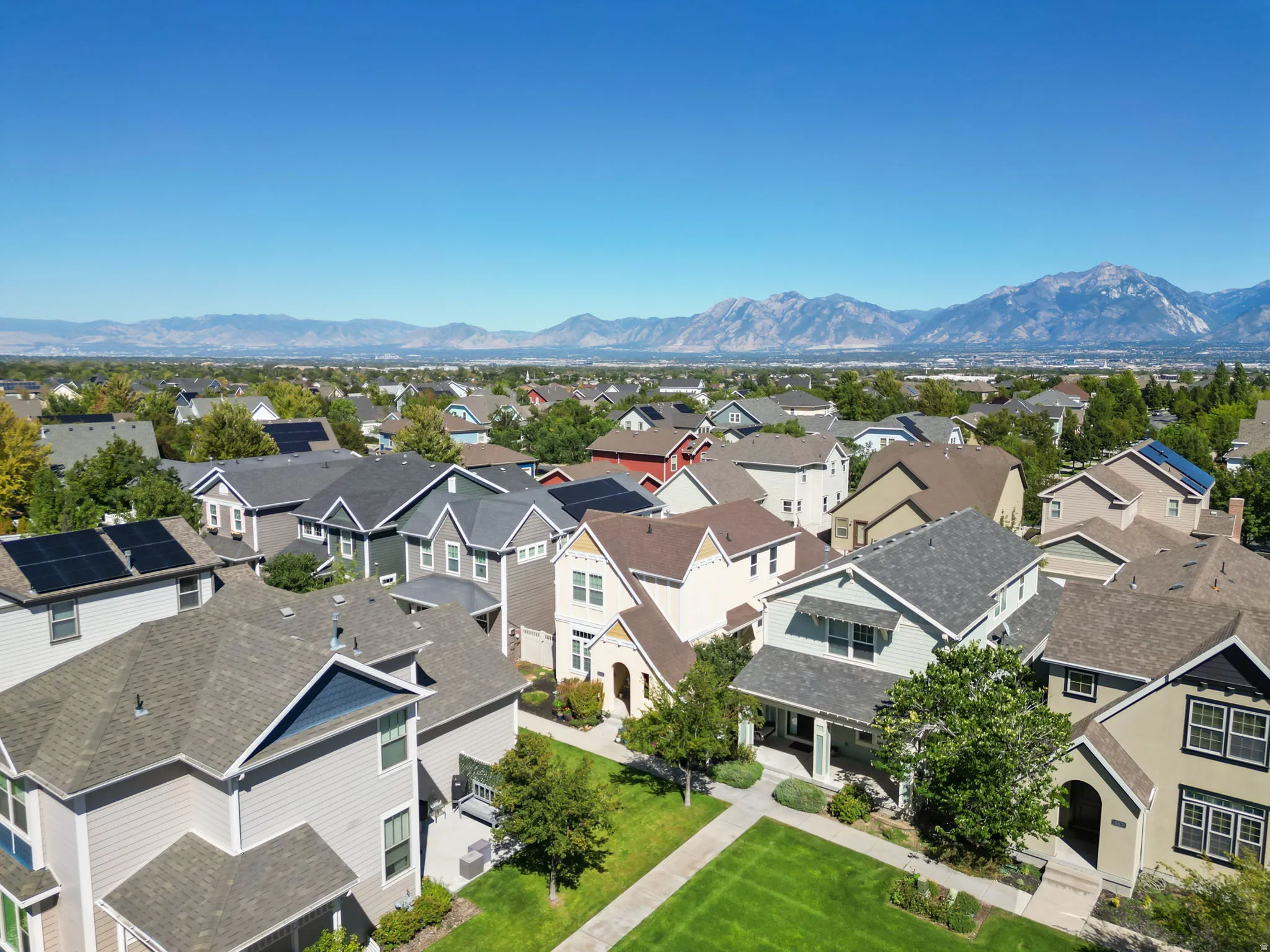 Expansive neighborhood setting with established homes, mature trees, and mountainous backdrop