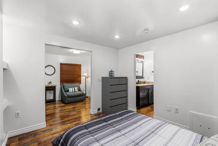 Recessed ceiling lighting, wood-finish flooring, and white painted walls