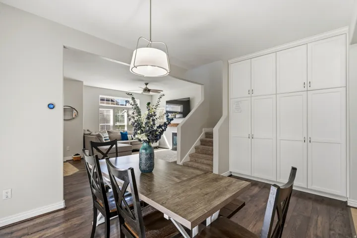 Hardwood-finish flooring, built-in white panel cabinetry, contemporary pendant lighting, and an open concept layout