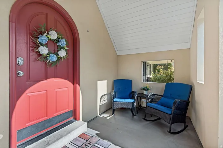 Arched entry door with a digital keypad and an overhead porch light