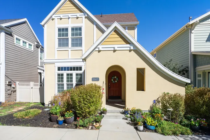 Stucco exterior with decorative trim, arched entry, and a pitched roof