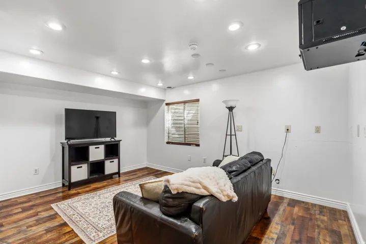 Recessed ceiling lighting, wood-finish flooring, white baseboards, and a window with blinds