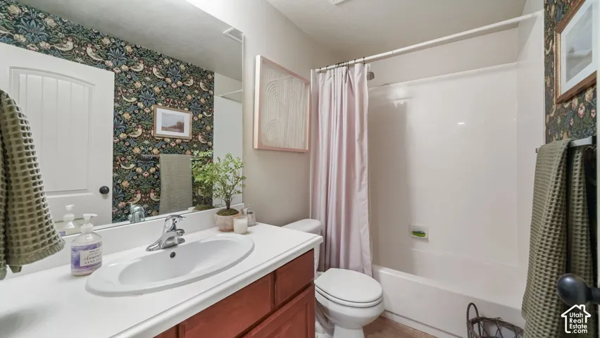 Upstairs Guest On-Suite Bathroom vanity with white countertop, integrated sink, and wood-finish cabinetry