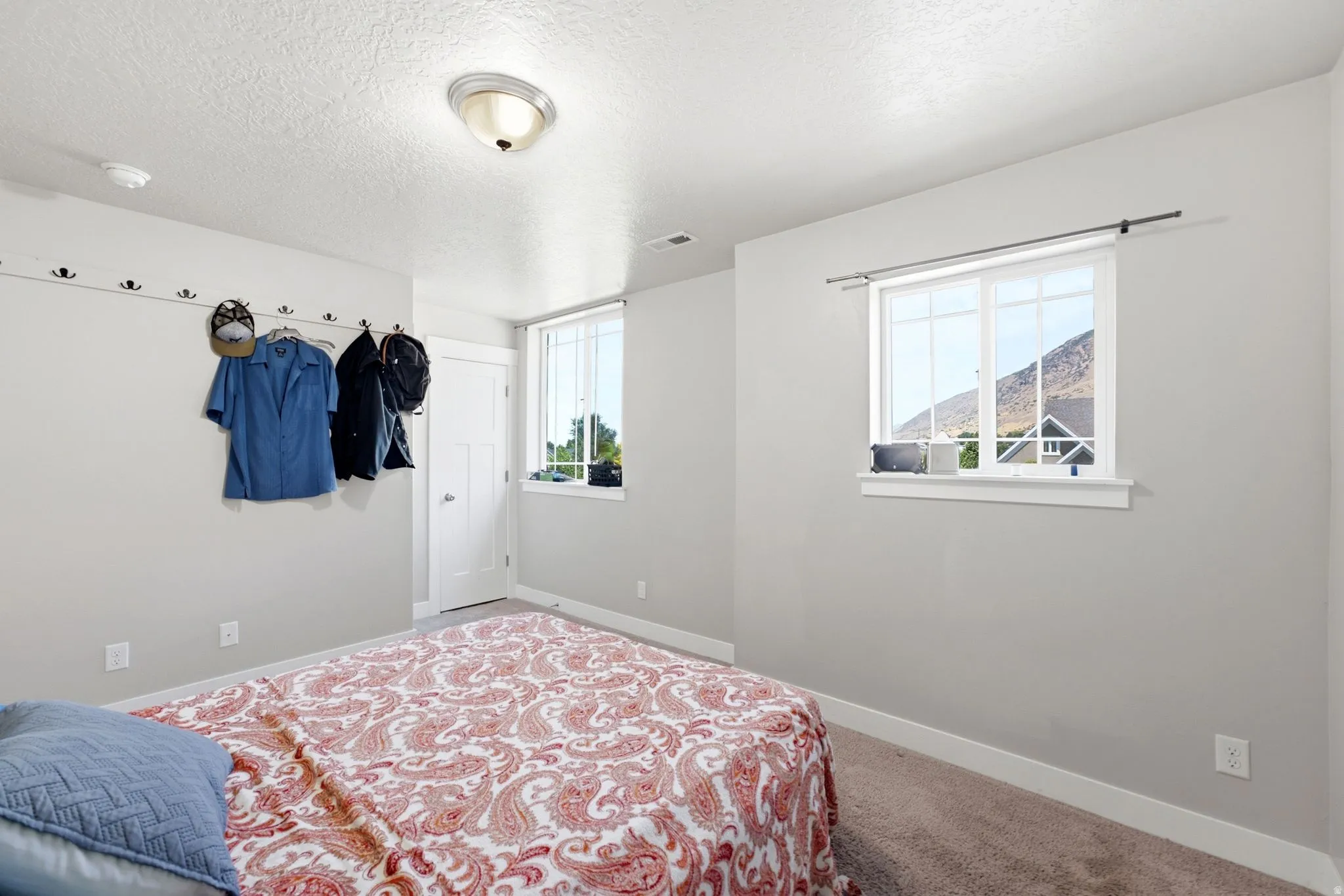 Carpeted bedroom with neutral wall paint and white trim