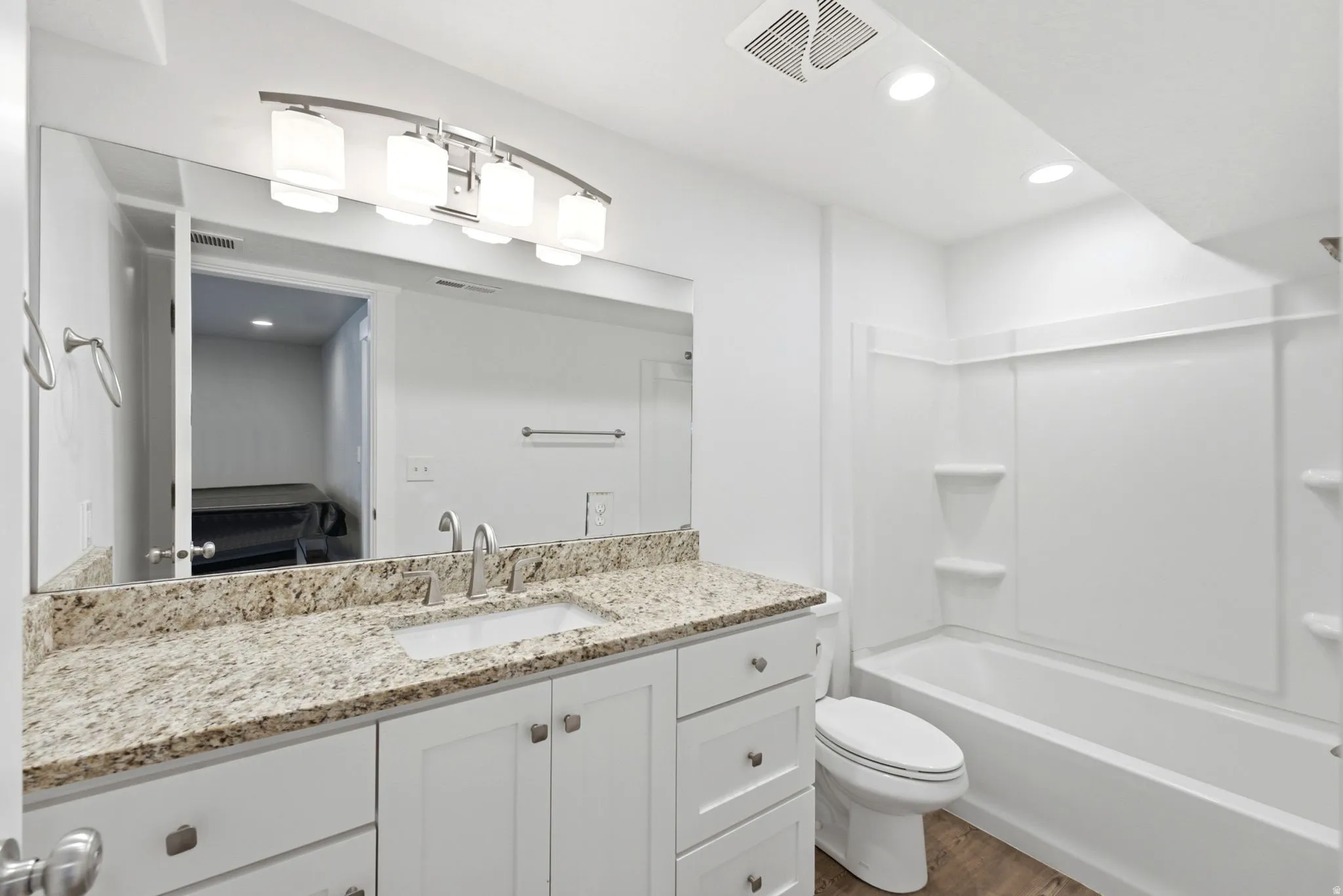 Bathroom featuring a white vanity with brushed nickel hardware, granite-style countertop, and an undermount sink