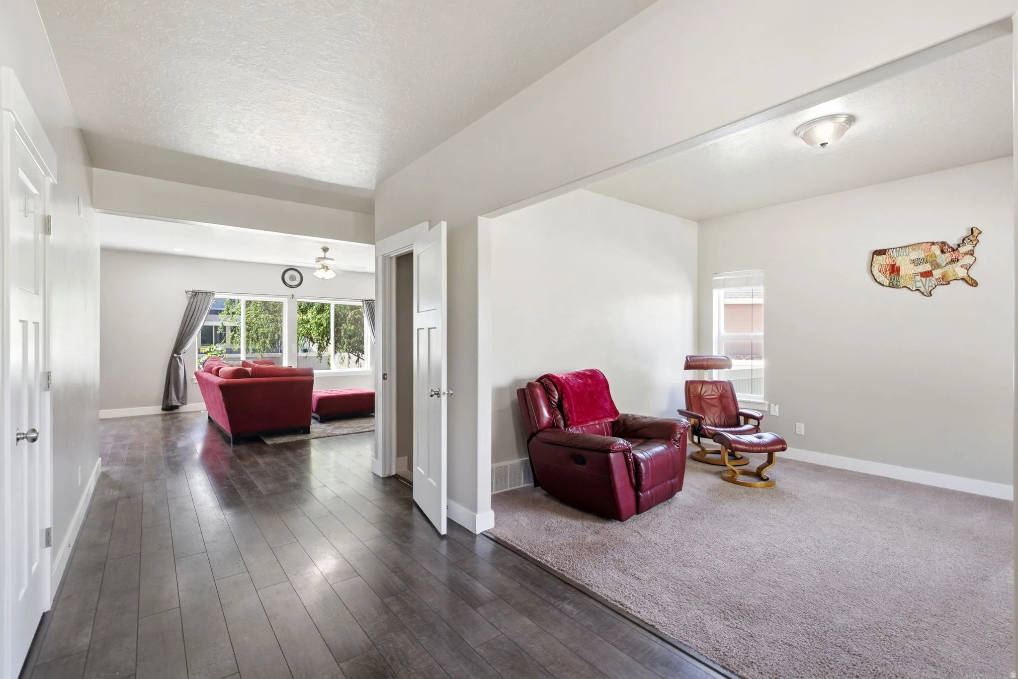 Hallway featuring wood-finish flooring, white paneled interior doors, and a vaulted ceiling