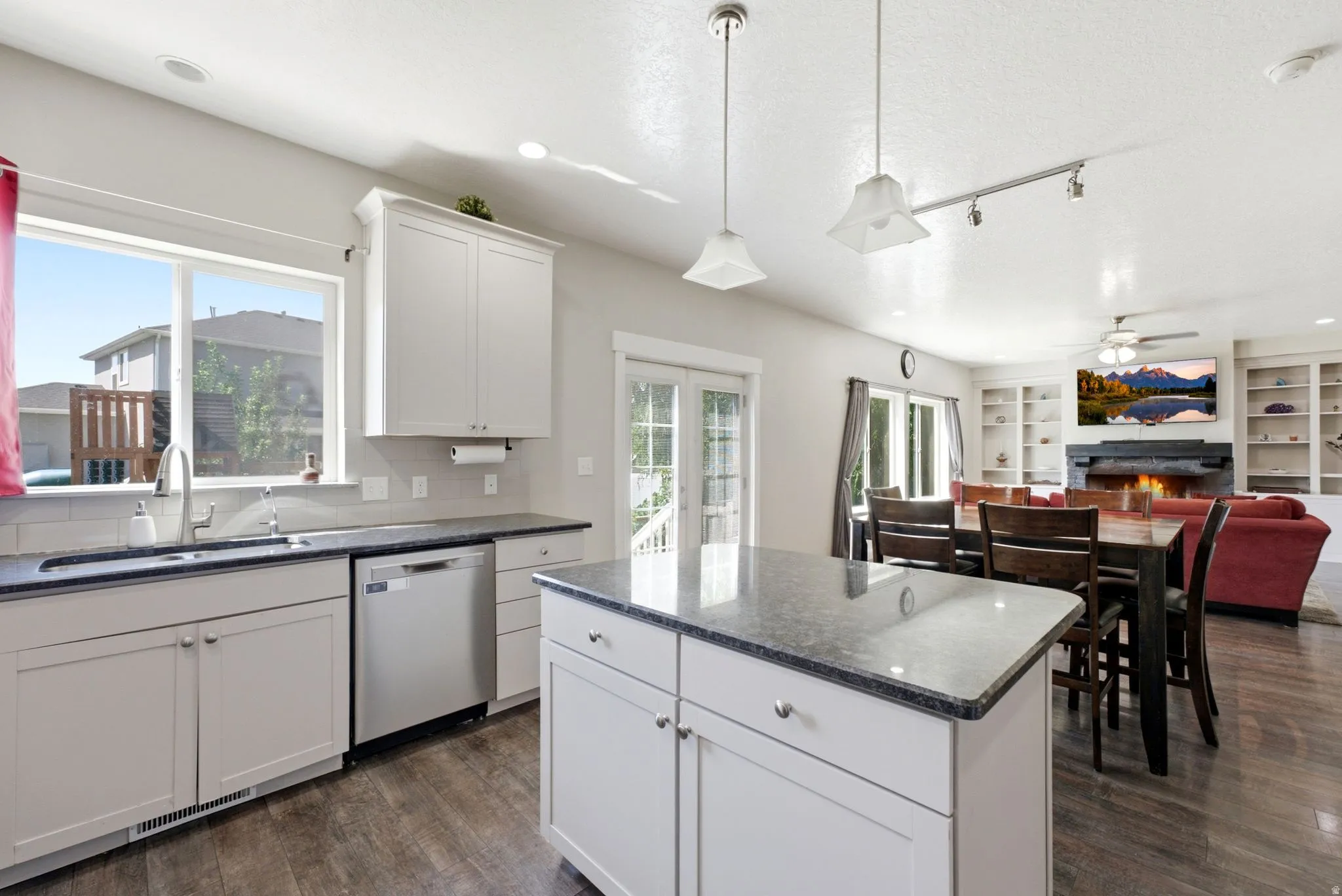 Contemporary kitchen featuring an island, white cabinetry, stainless steel appliances, and a tile backsplash
