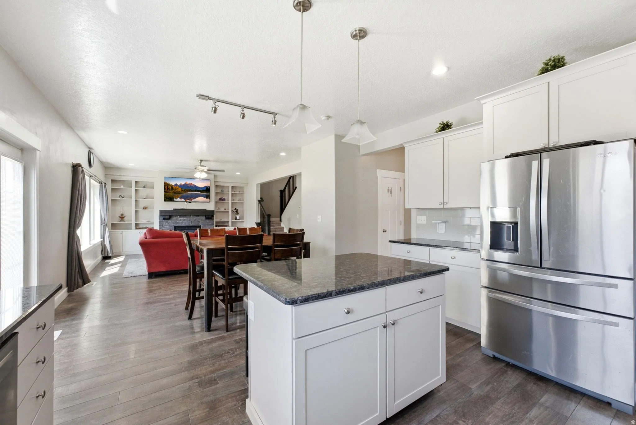 Kitchen island with a dark countertop and white cabinetry