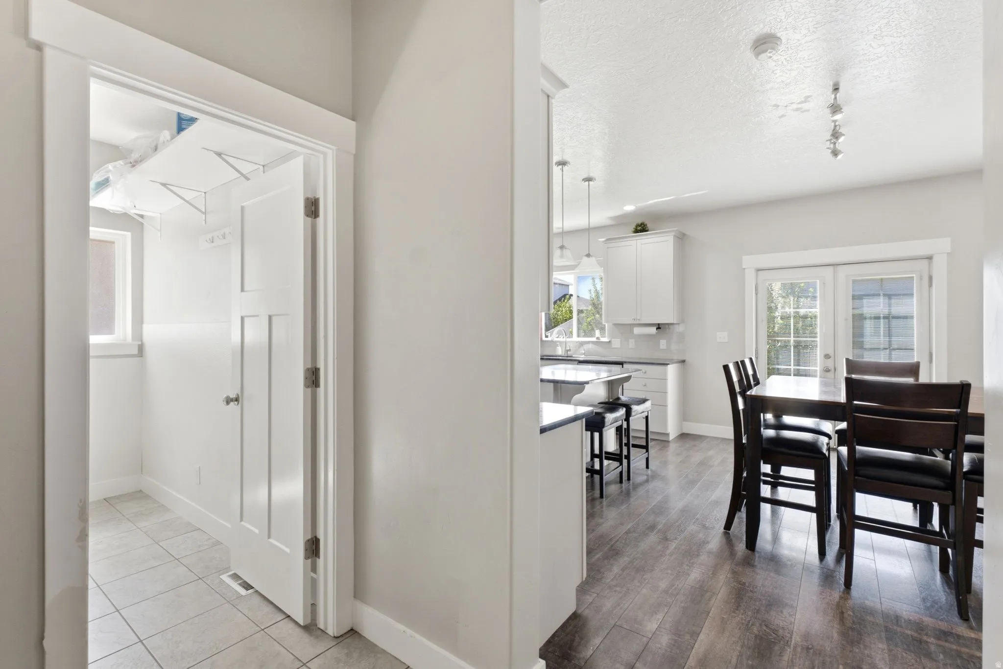 Interior hallway with wood-finish flooring extending into the dining area and kitchen