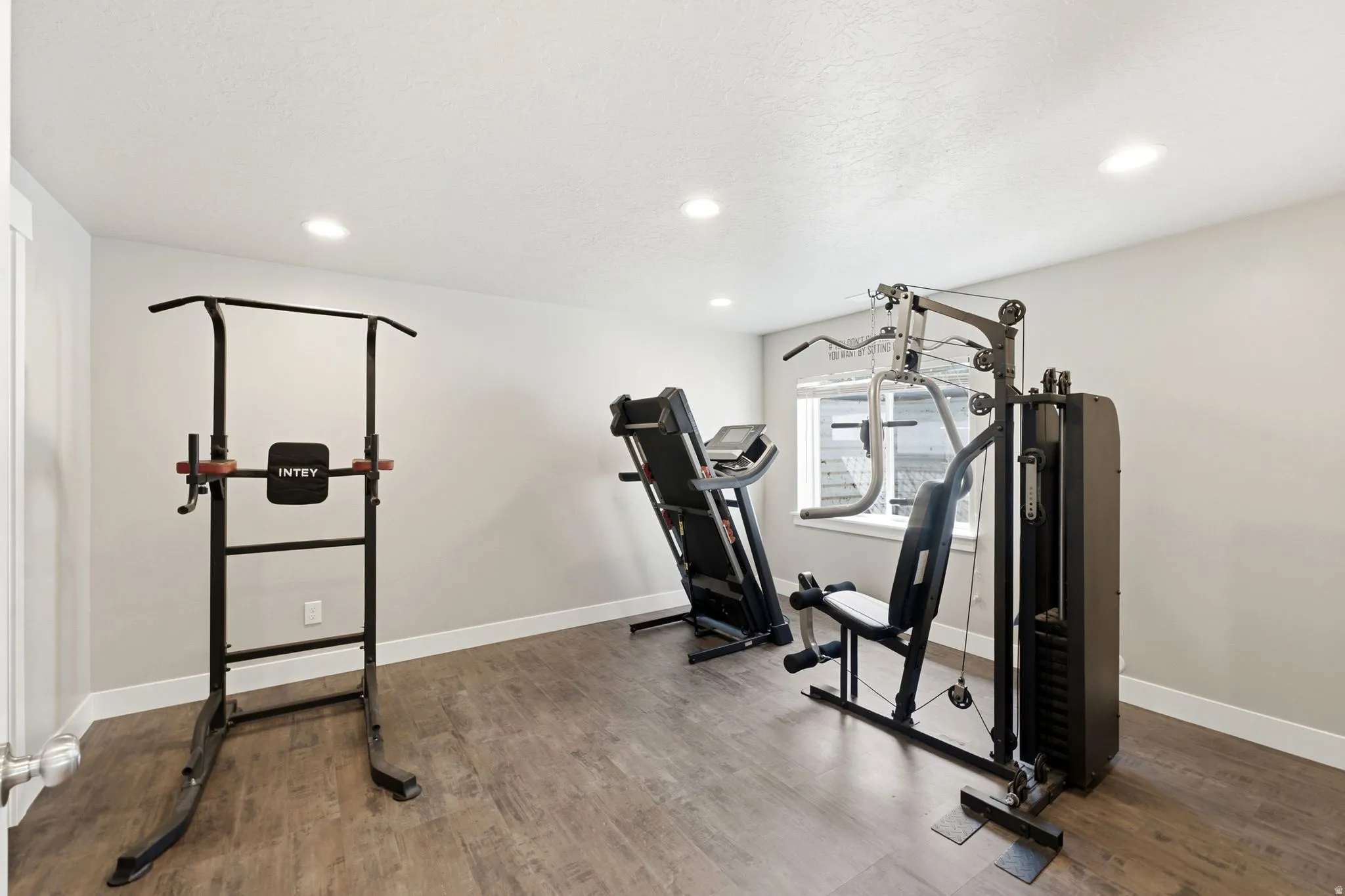 Versatile room featuring wood-finish flooring, recessed lighting, and a window for natural light