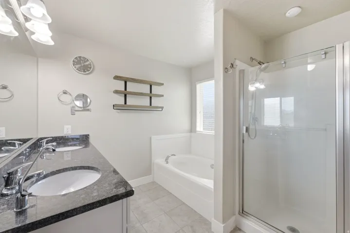Dual vanity with dark granite-style countertops and chrome fixtures