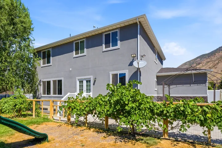 Two-story residence featuring a gray stucco exterior and white-framed windows