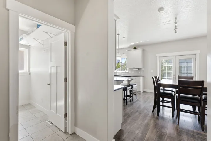 Interior hallway with wood-finish flooring extending into the dining area and kitchen