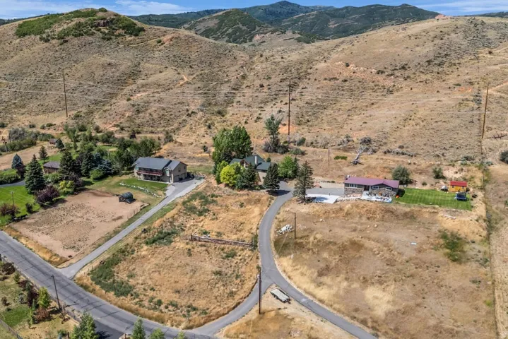 Expansive property featuring mountainous terrain and a large, paved driveway