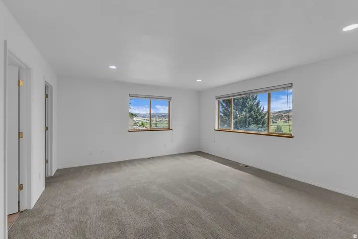 Spacious interior room featuring two large windows with natural wood sills, offering expansive landscape scenery