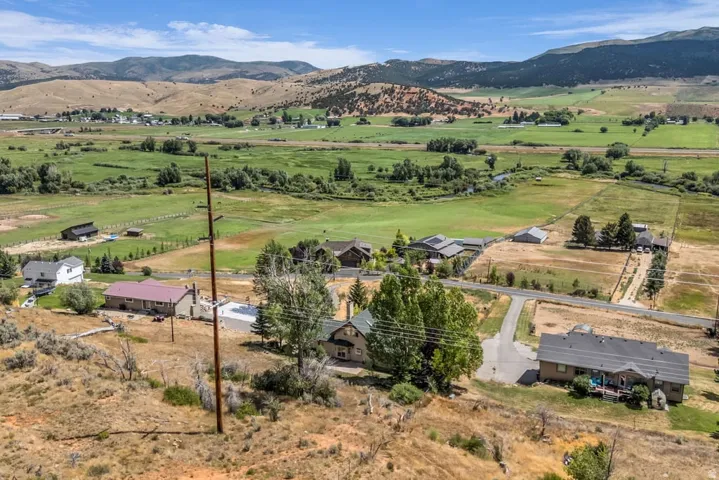 Expansive valley setting featuring a mix of residential properties, agricultural fields, and natural terrain