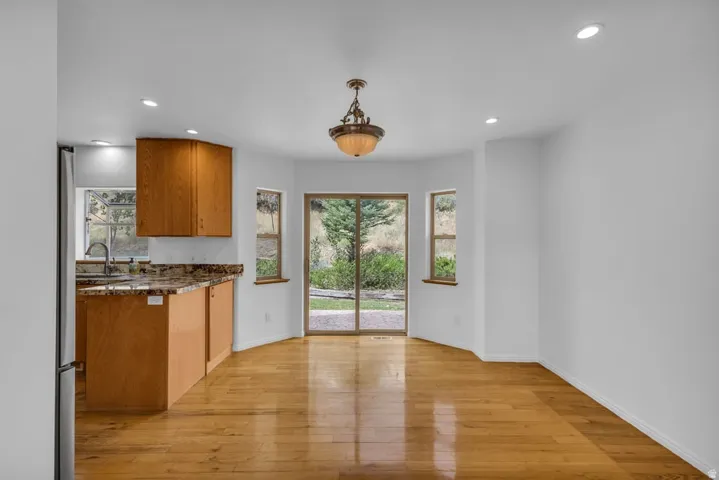 Open-concept dining area featuring wood-finish flooring, a decorative chandelier, and recessed lighting