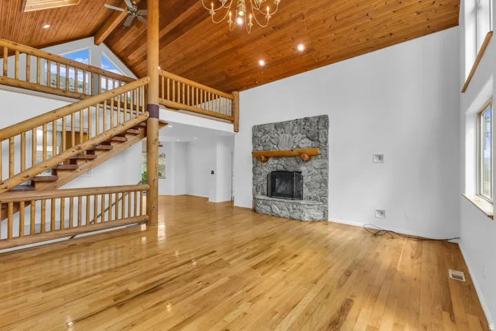 Spacious interior featuring a prominent log staircase and an upper-level balcony overlooking the main area