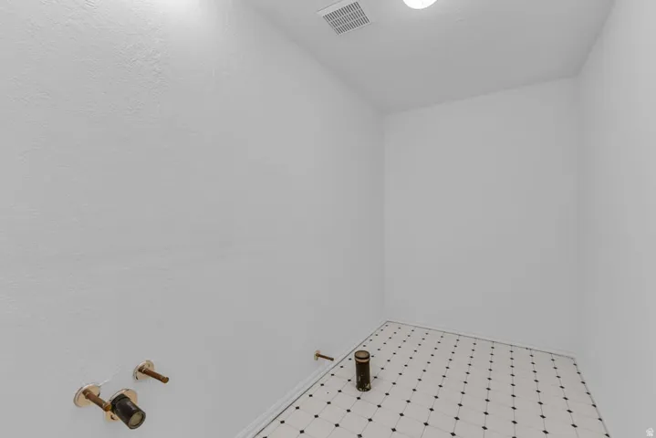 Compact interior space featuring light-toned walls and black-and-white patterned floor tiling