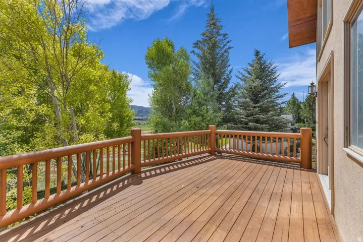 Spacious outdoor deck featuring natural wood decking and rustic log railing