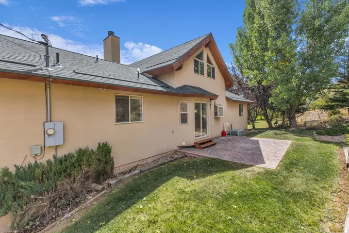Expansive rear patio featuring stamped concrete, offering direct access to the interior via double sliding glass doors