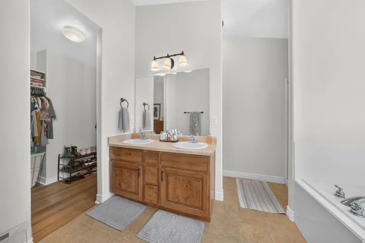 Large primary bathroom with walk-in closet and double sinks